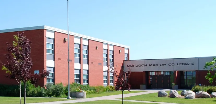 L'edificio in mattoni a più piani del Murdoch Mackay Collegiate è circondato da un prato con grandi pietre.