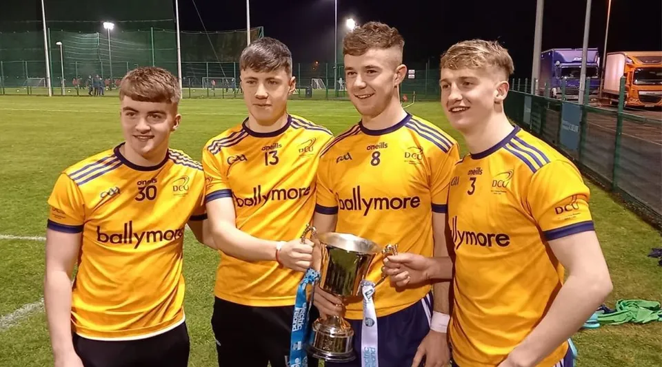 Un gruppo di studenti della Patrician High School si trova sul campo sportivo tenendo in mano un trofeo.