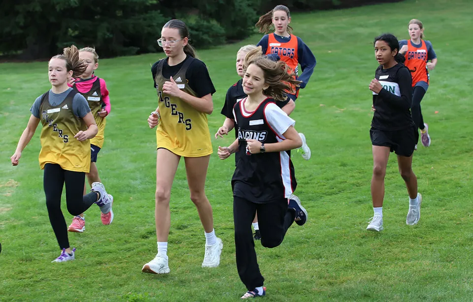 Giovani atlete corrono insieme su un campo del campus della Lethbridge School Division.