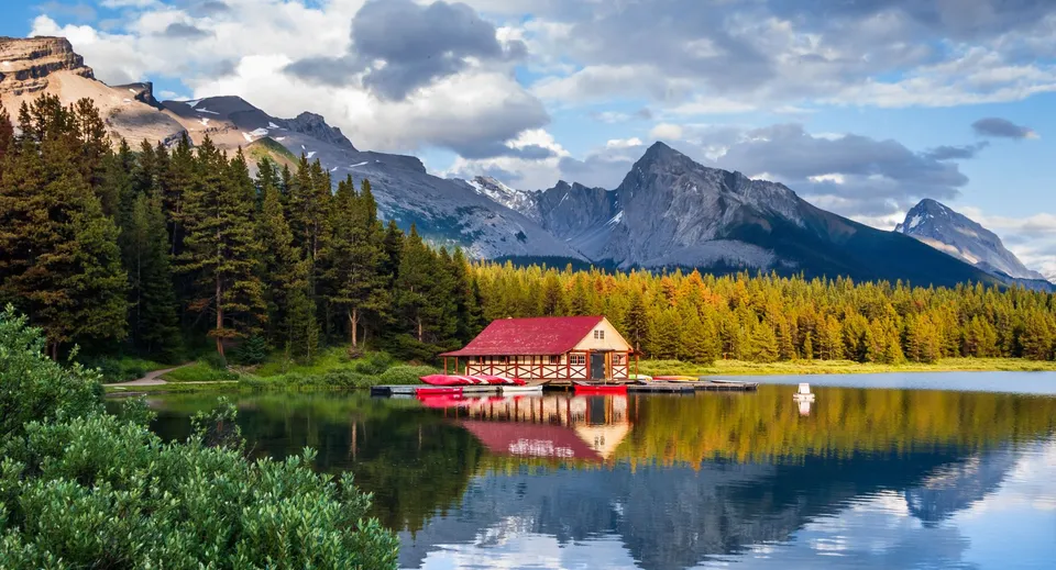 Una rimessa per barche rossa su un lago davanti a un paesaggio montano sul terreno della Lester B. Pearson Catholic High School.