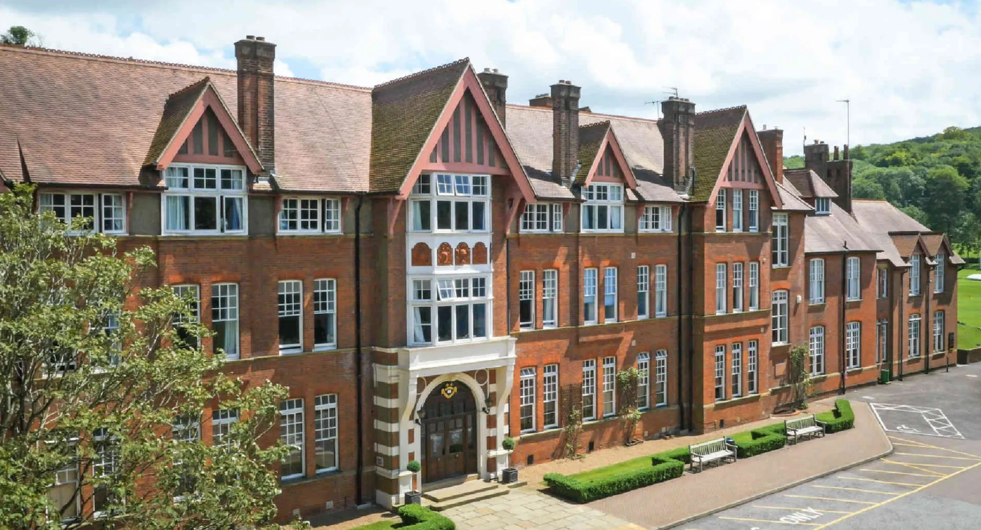 L'edificio in mattoni a più piani della Caterham School in stile Tudor è circondato da un verde rigoglioso.