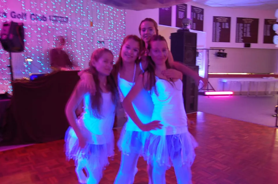 Studentesse della Whangamata Area School posano insieme in una stanza decorata a festa.