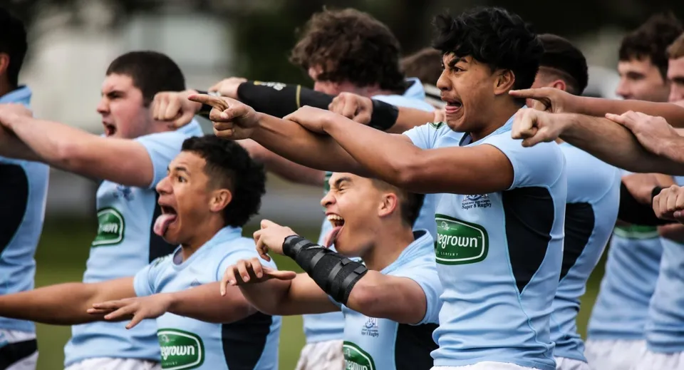 Studenti della Napier Boys High School festeggiano insieme un'attività di squadra sportiva all'aperto.