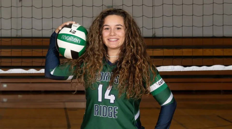 Una studentessa della Forest Ridge School of the Sacred Heart tiene in mano un pallone da pallavolo nella palestra.