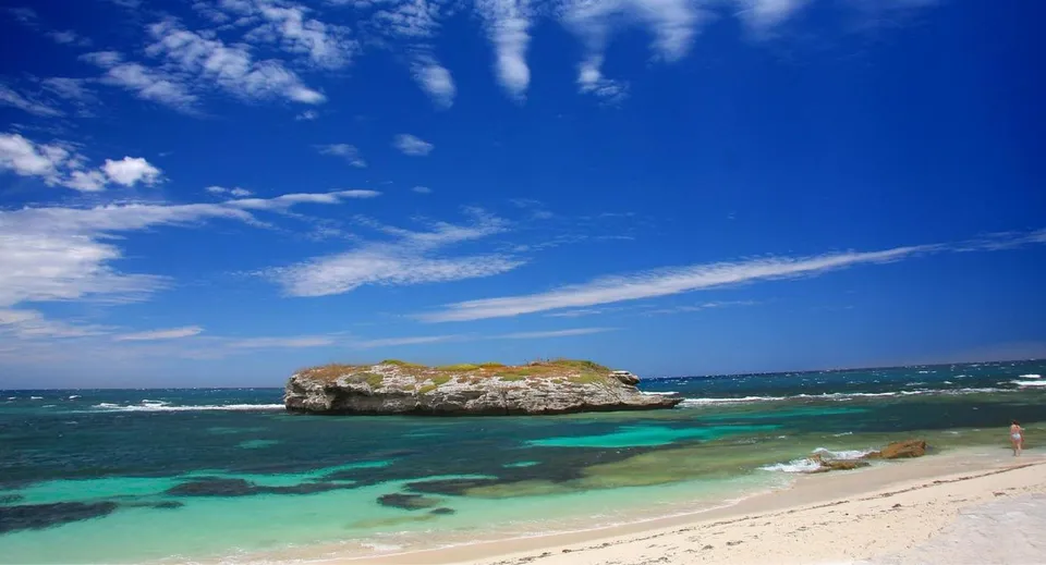 Un paesaggio di spiaggia tropicale con un'isola rocciosa in primo piano, fotografato nei pressi della Elanora State High School.
