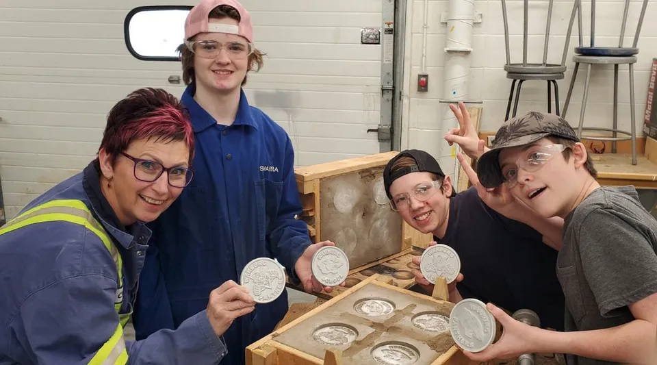 Studenti della Warburg School lavorano in laboratorio ed esaminano pezzi di ceramica su un tavolo di legno.