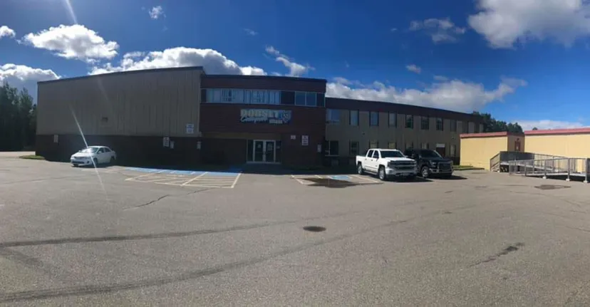 L'edificio moderno a più piani con facciata in vetro nel campus del Dorset Collegiate è circondato da un parcheggio pavimentato.
