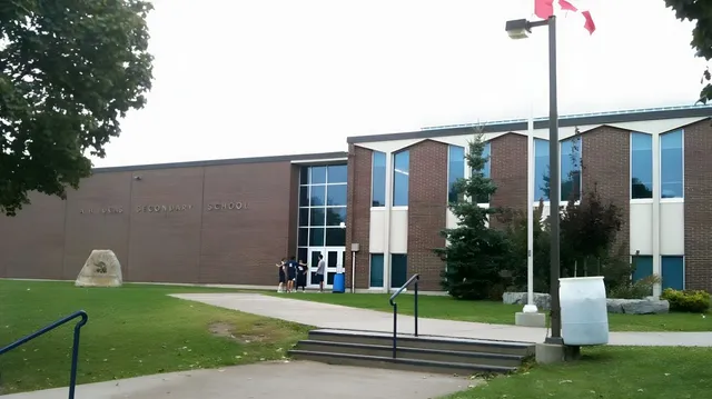 Das mehrstöckige Backsteingebäude der A.B. Lucas Secondary School mit großen Fenstern und kanadischer Flagge im Vordergrund.