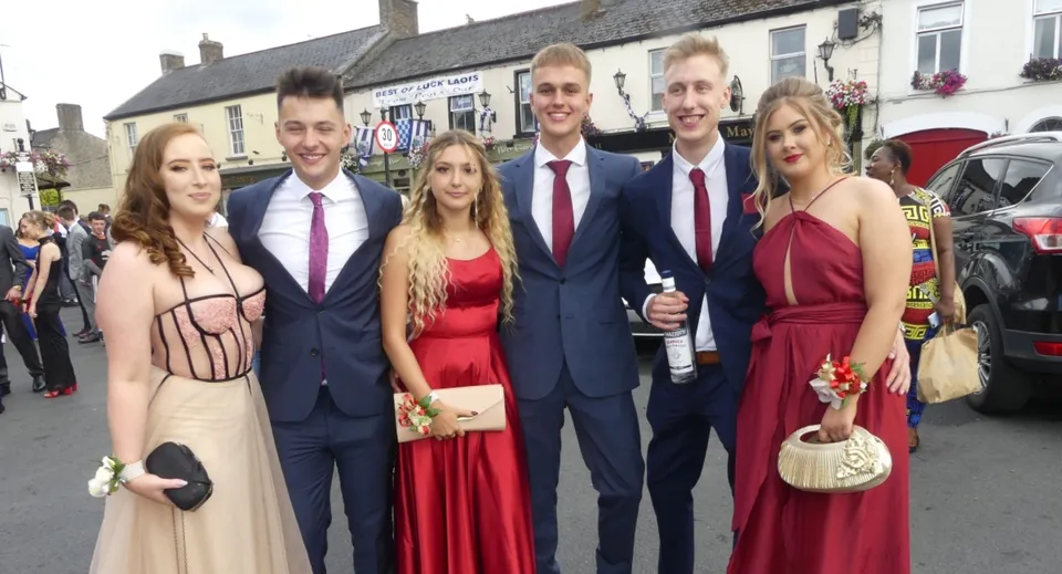 Un gruppo di persone si trova davanti a un piccolo luogo nel campus del Kilkenny College.