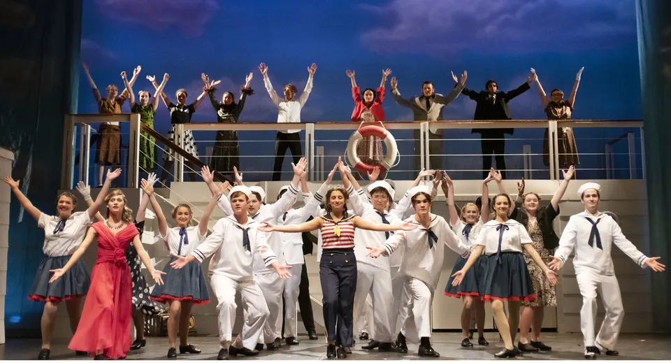 Un gruppo di studenti del Schull Community College in diversi costumi su un palco davanti a un cielo nuvoloso.