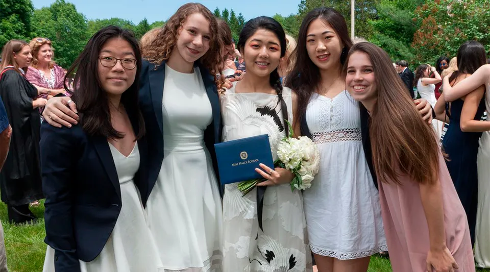 Un gruppo di giovani donne è insieme nell'area verde all'aperto del campus della Miss Hall’s School.