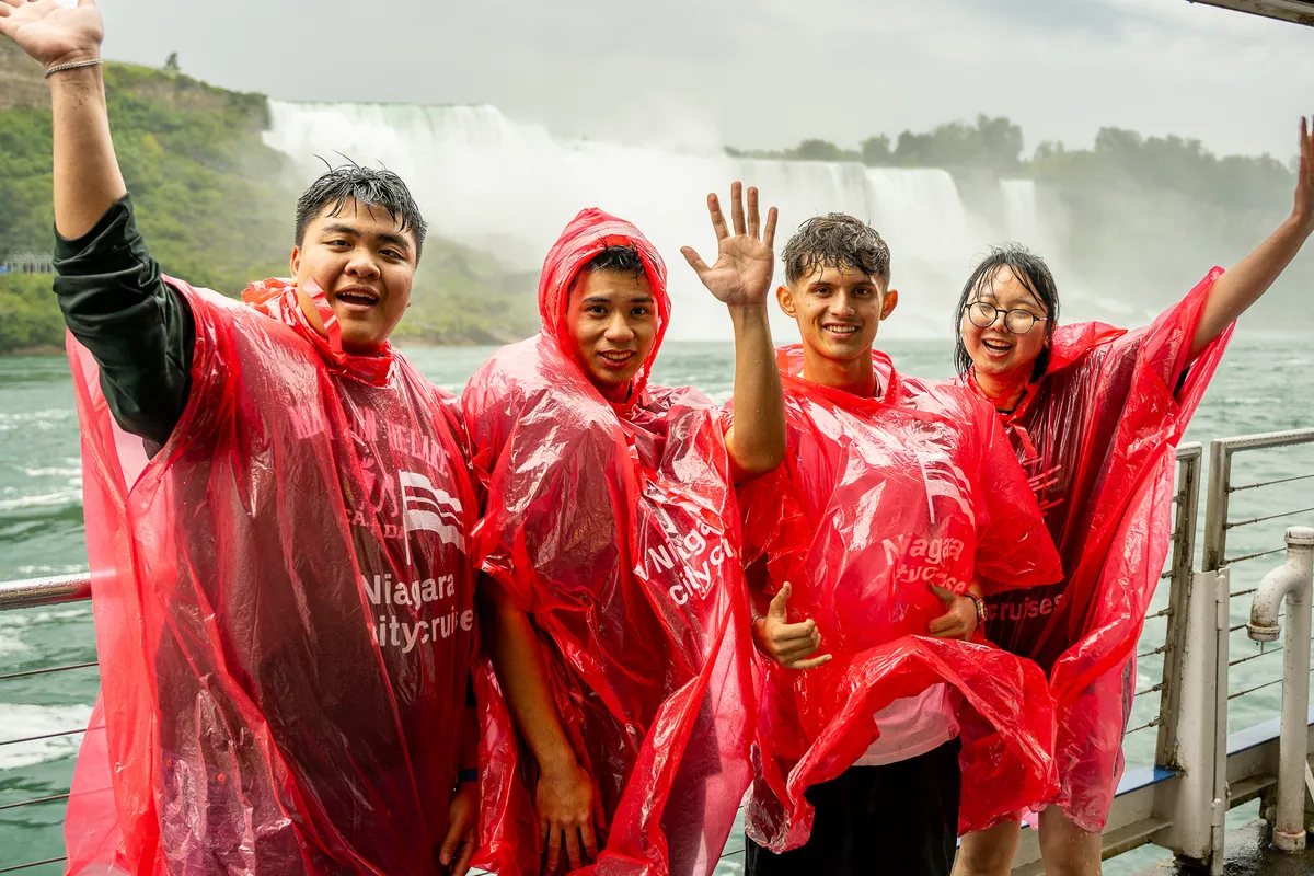Schüler in roten Regenponchos vor den Niagarafällen