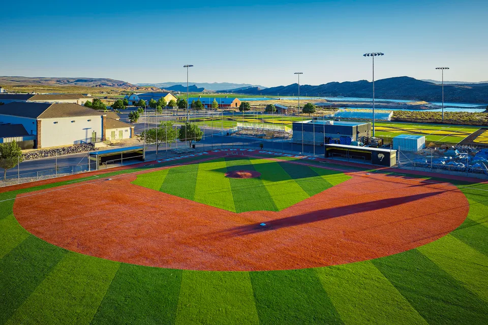Il campo da baseball della Utah Prep Academy in erba sintetica con edifici sullo sfondo.