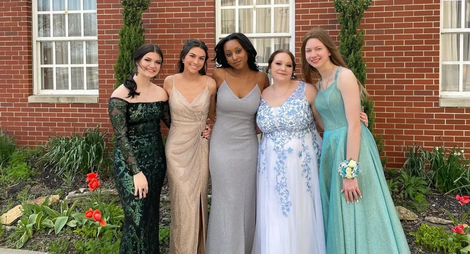 Un gruppo di cinque studentesse della Middletown Christian School sta davanti a un edificio in mattoni con uno sfondo verde.