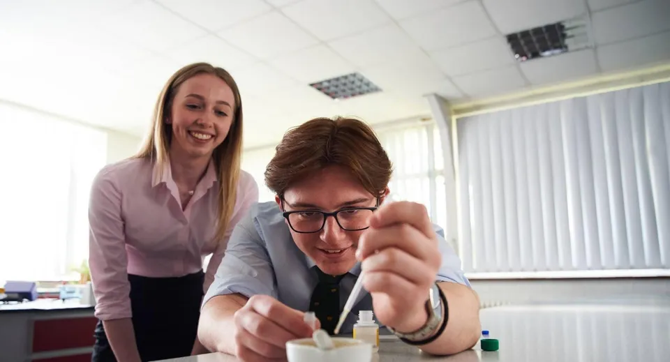 Due persone interagiscono in modo cordiale in un ufficio nel campus del Denstone College.