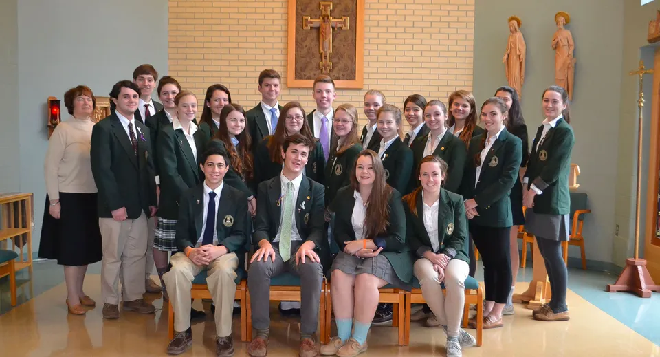 Un gruppo di studenti si riunisce in una stanza con immagini religiose nel campus della Bishop Brady High School.