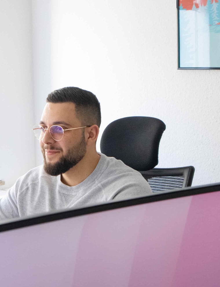 Mitarbeiter von Kulturwerke Deutschland am Schreibtisch vor seinem Bildschirm