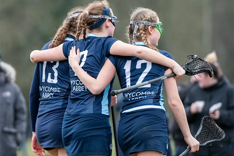 Dos jóvenes deportistas se abrazan en el campo de deportes de Wycombe Abbey School.