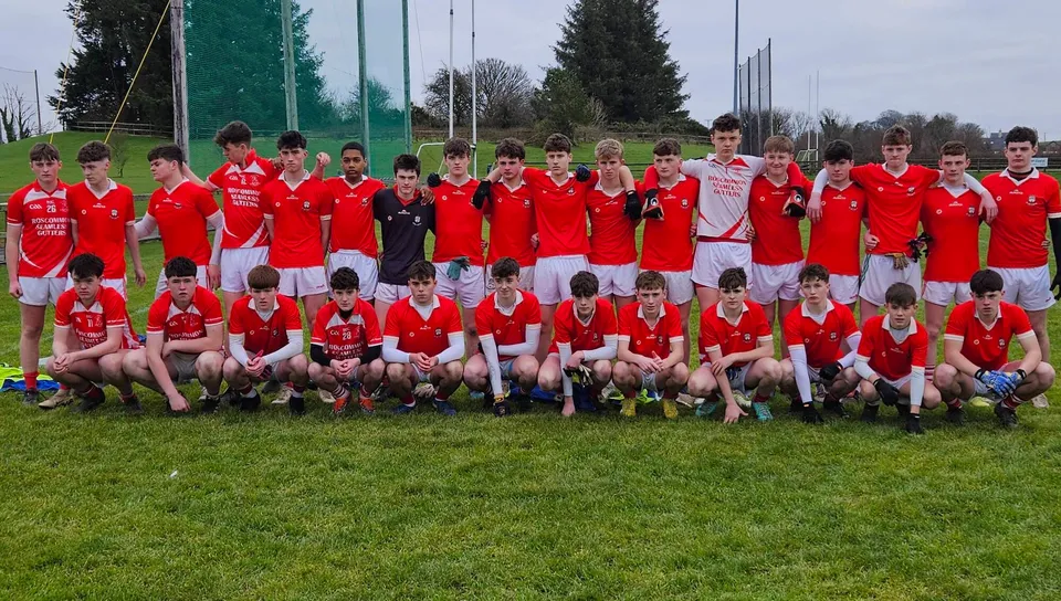 Un grande gruppo di giovani calciatori in maglia rossa sul campo sportivo del C.B.S. Roscommon.