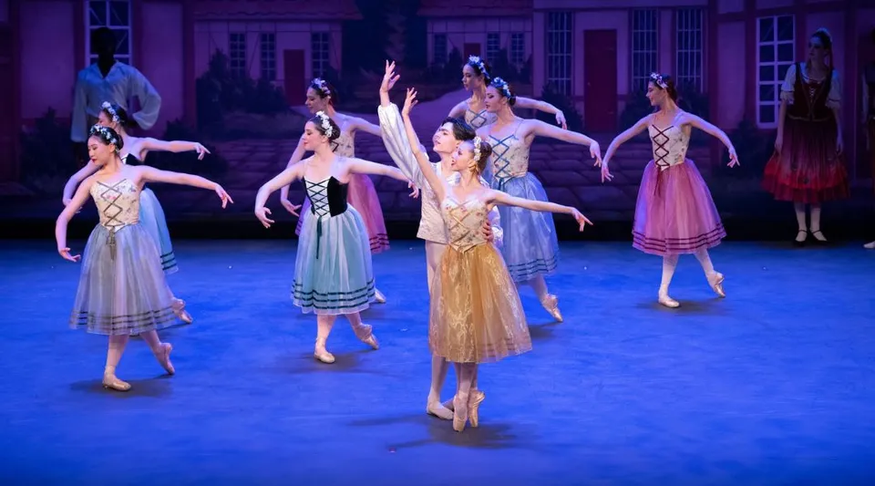 Studentesse della Walnut Hill School for the Arts si esibiscono in un balletto con costumi colorati su un palco con elementi architettonici ricchi di decorazioni.