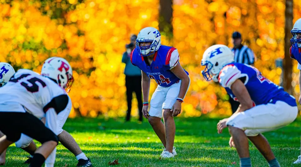 Studenti della Holderness School durante una partita di calcio sul campo da gioco in un ambiente autunnale.