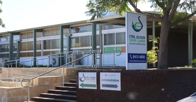Das mehrstöckige Gebäude des Cyril Jackson Senior Campus zeigt das grüne Logo und Eingangsbereich mit Stufen und Bäumen.
