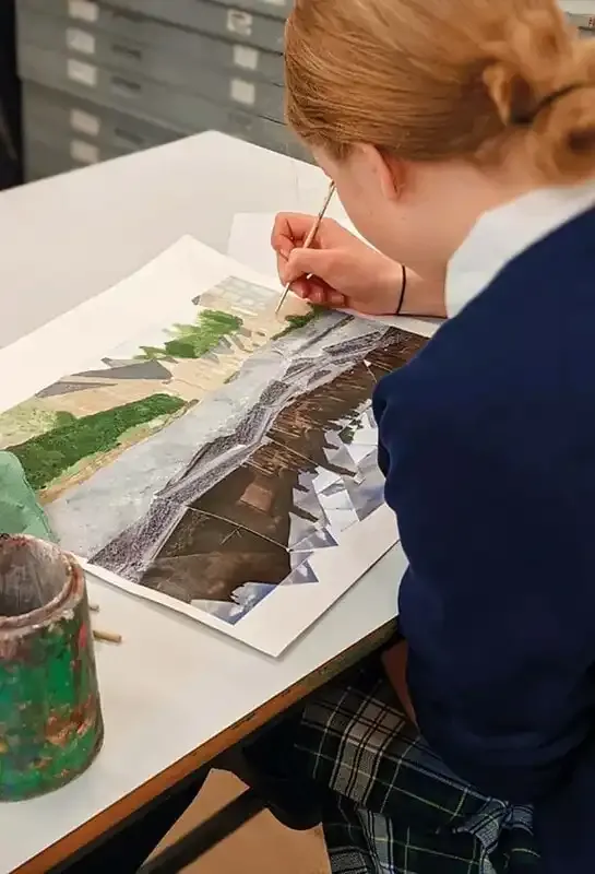 Studentessa in divisa dipinge un acquerello durante una lezione d'arte a scuola
