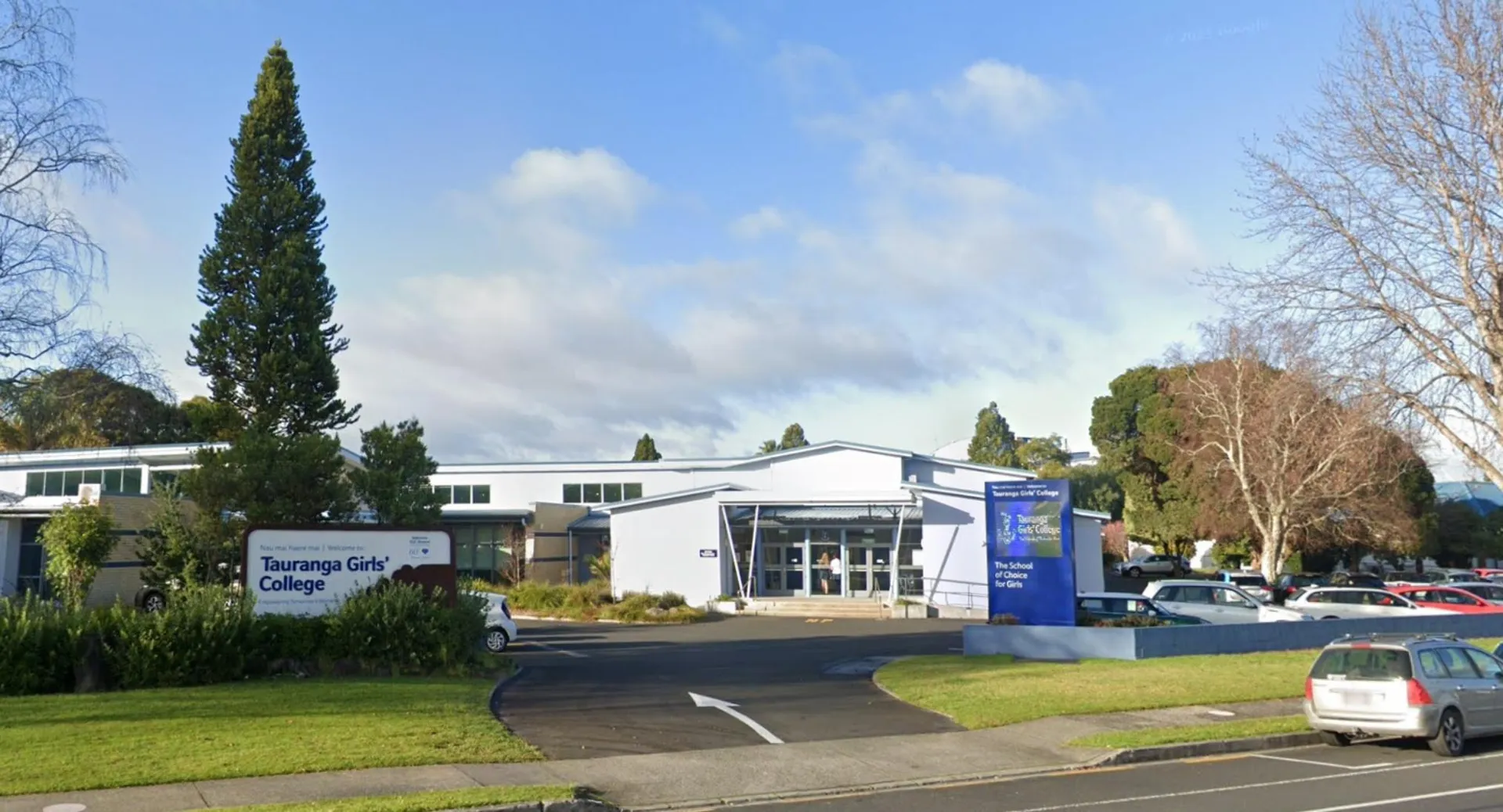 Il campus del Tauranga Girl´s College con un moderno complesso edilizio, circondato da alberi e parcheggi.