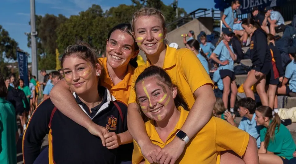 Un gruppo di giovani donne si trova davanti a una folla nel campus del Scotch Oakburn College.