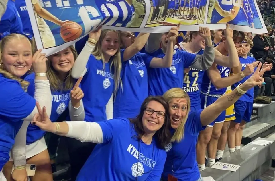 Studentesse della Catholic Central High School esultano e festeggiano nell'area sportiva con striscioni sullo sfondo.