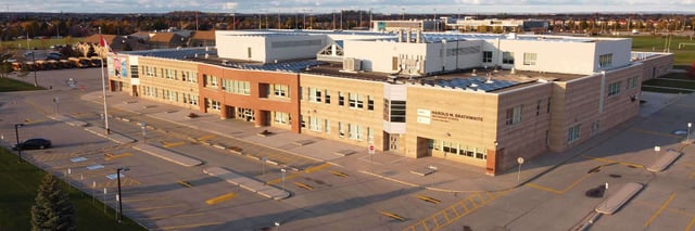 Das große Gebäude der Harold M. Brathwaite Secondary School ist umgeben von Parkmöglichkeiten
