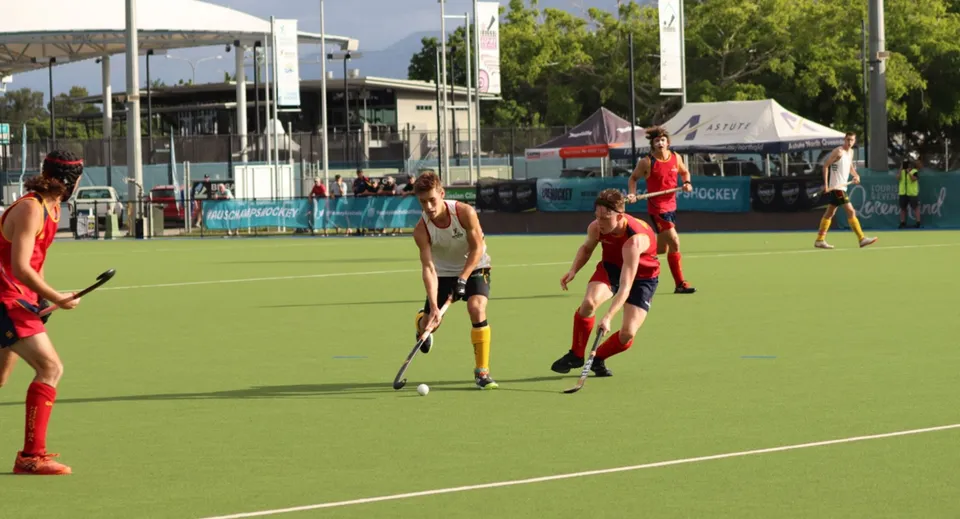Un gruppo di studenti e studentesse gioca a hockey su prato sul campo in erba sintetica del Hobart College.