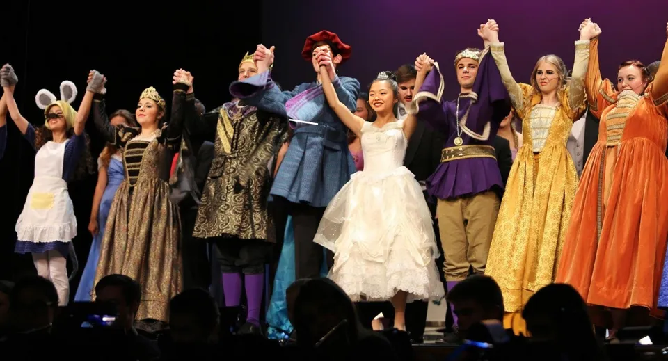 Un gruppo di studenti e studentesse della Notre Dame de la Baie Academy porta in scena una rappresentazione teatrale su un palco.