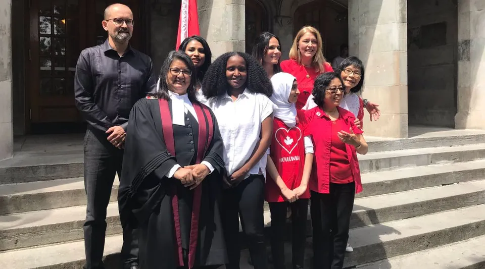 Un gruppo di studenti della Greenwood Secondary School posa sulle scale davanti a un edificio dopo la cerimonia di diploma.