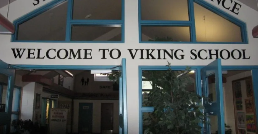L'ingresso della Viking School con un grande cartello di benvenuto sopra la porta e una vista sul corridoio attraverso le vetrate.
