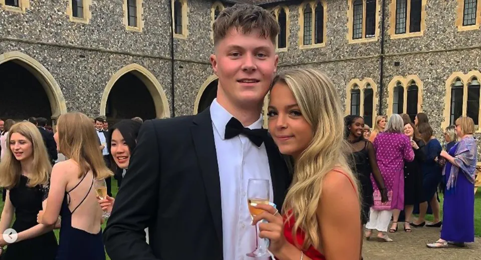 Una giovane coppia sta davanti all'edificio storico con archi e architettura decorata nel campus del Lancing College.