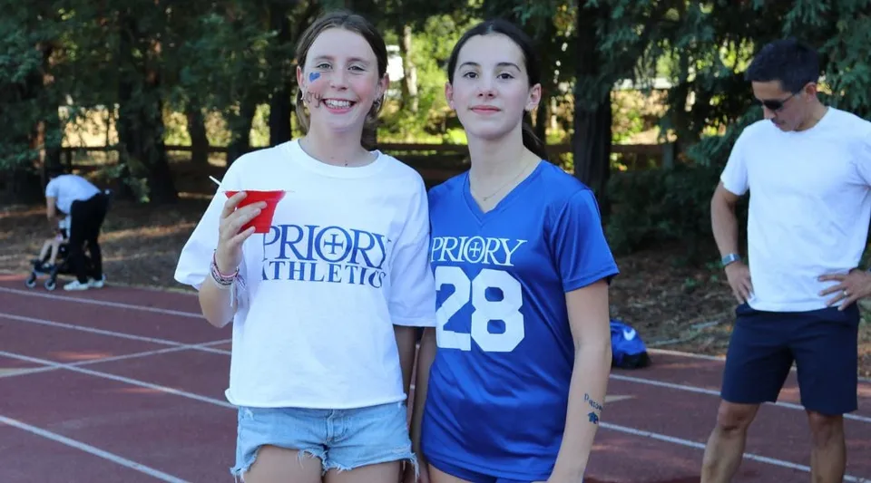 Due studentesse della Woodside Priory School sono in piedi sulla pista d'atletica nell'area sportiva della scuola.
