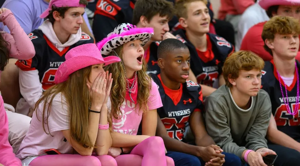 Un gruppo di tifosi sostiene attivamente la propria squadra durante un evento sportivo sul campus della Kingswood Oxford.