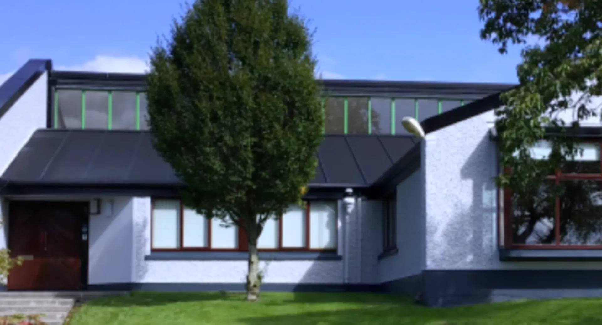 Un edificio moderno a due piani con facciata bianca e ampie finestre nel campus del Coláiste Mhuire Ballymote.