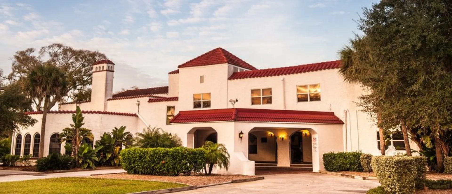 L'edificio principale della Florida Preparatory Academy in stile spagnolo con tegole rosse e palme in primo piano.