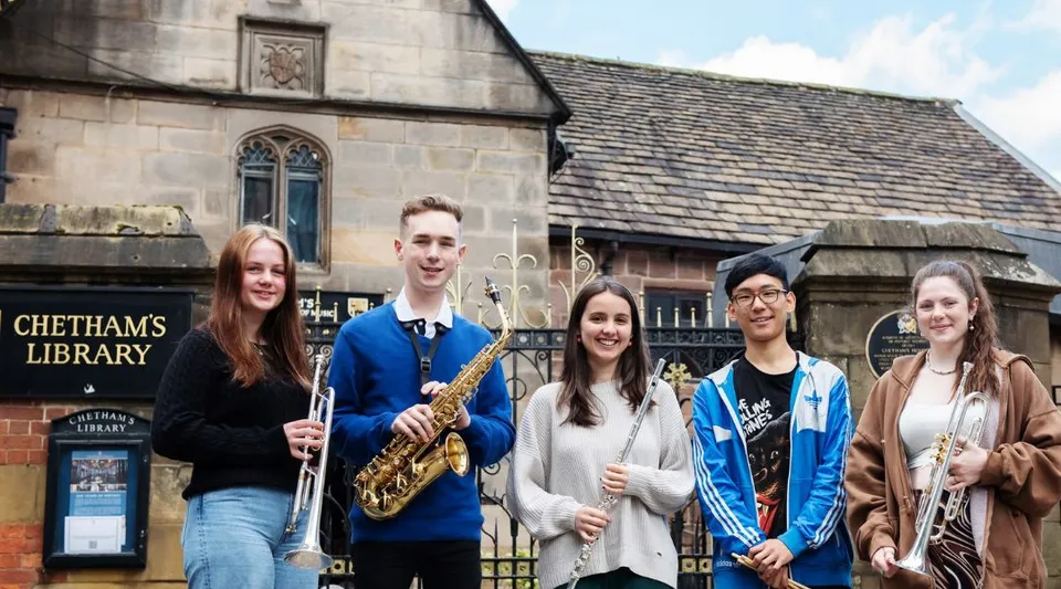 Un gruppo di cinque studenti sta davanti all'edificio storico della Chetham’s School of Music.