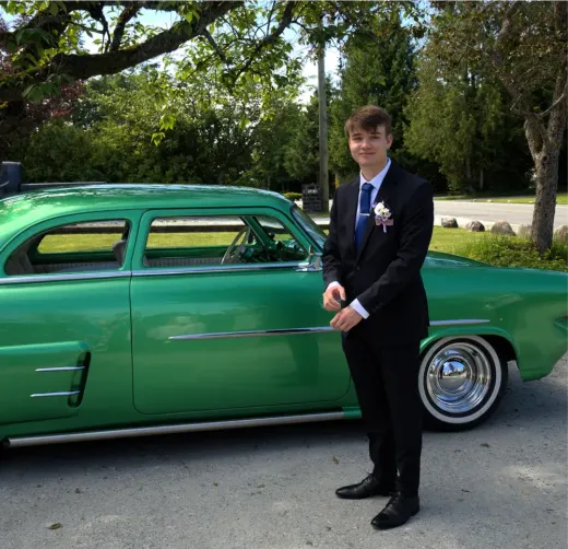 Stefan im Anzug neben einem grünen Oldtimer während seines Auslandsjahres in Kanada