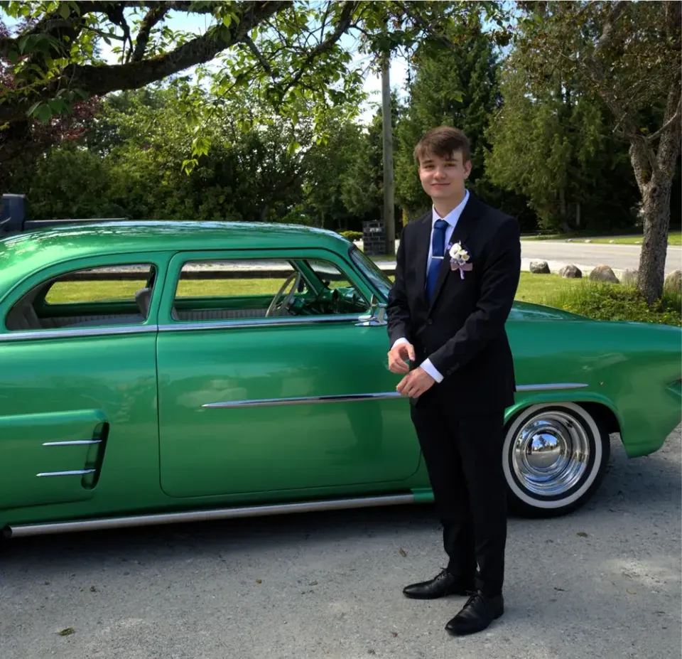 Stefan im Anzug neben einem grünen Oldtimer während seines Auslandsjahres in Kanada