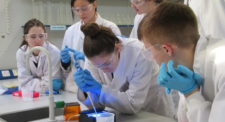 Gli studenti del St. Andrew's College lavorano in laboratorio con strumenti e materiali scientifici su un tavolo.
