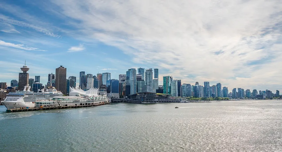 Lo skyline di Vancouver visto dall'acqua con grattacieli, l'edificio Canada Place e una nave da crociera ormeggiata.