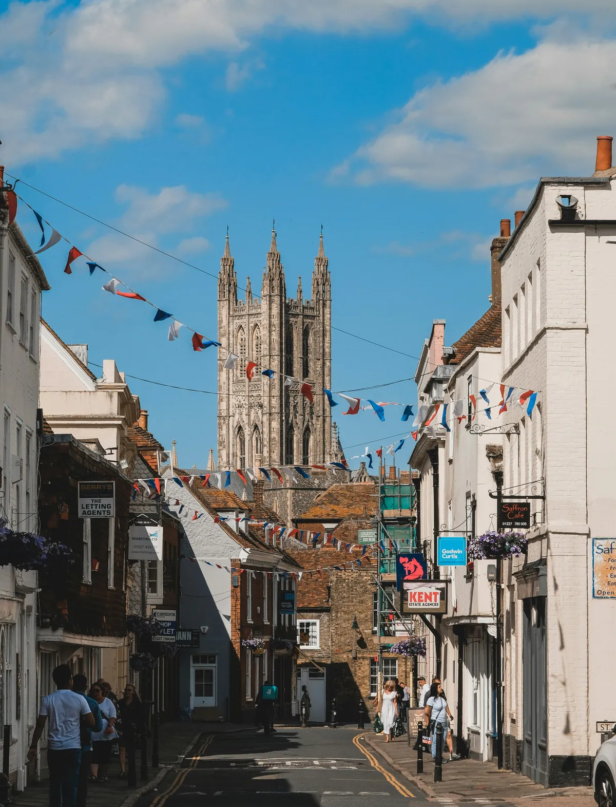 Calle peatonal de Canterbury con banderines y las torres de la catedral al fondo