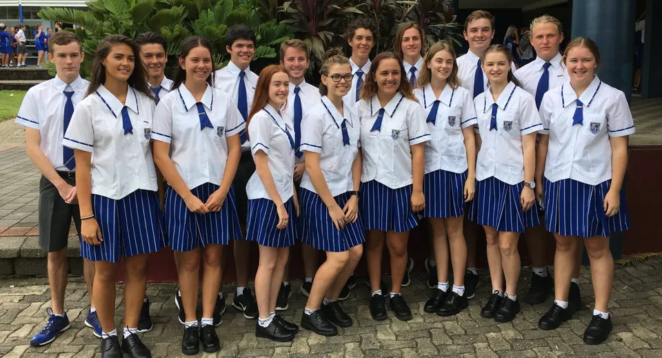 Un gruppo di studenti della Mackay North State High School è insieme all'aperto su un viale lastricato, circondato dal verde.