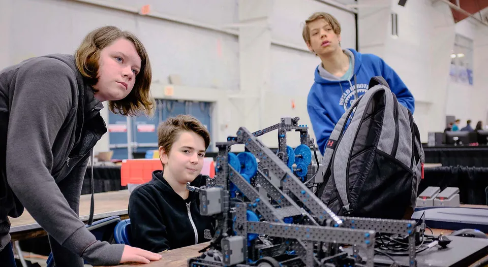Due studenti e un adulto lavorano insieme a un progetto di robotica nell'officina della Mark R. Isfeld Secondary School.