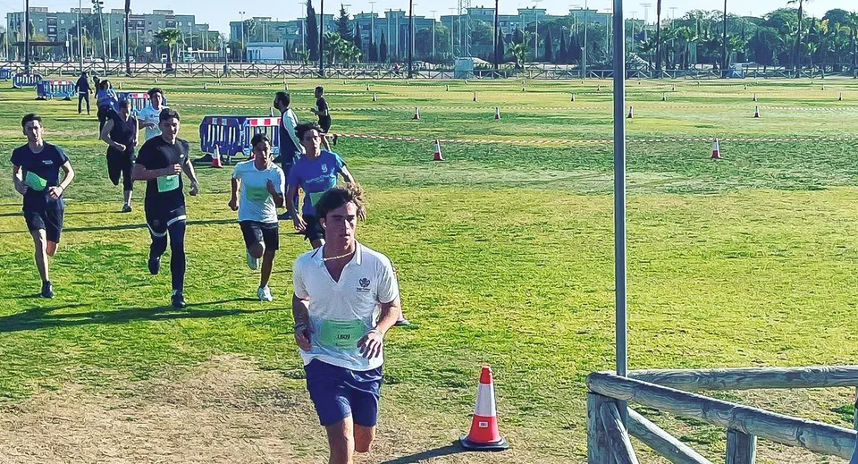 Un gruppo di calciatori si trova sul campo sportivo del Sage College con degli edifici sullo sfondo.