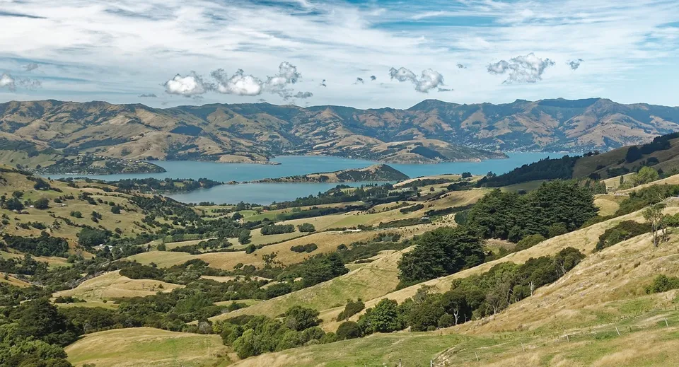 Paesaggio con colline, lago e montagne sotto un cielo nuvoloso vicino alla Middleton Grange School.